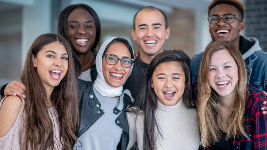 Group of students standing together for group picture smiling and laughing