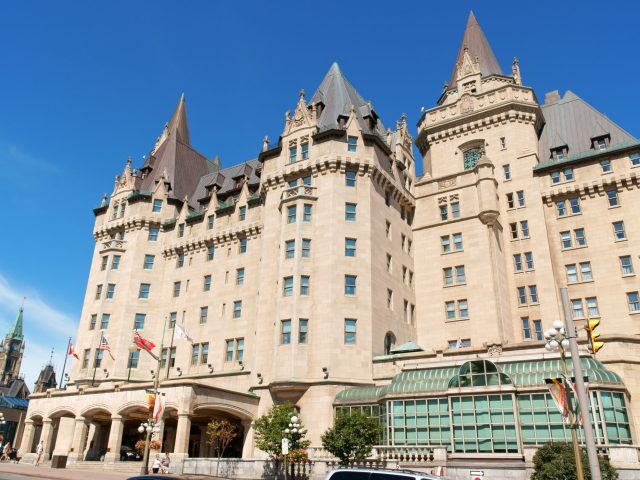 Ottawa, Canada - August 08, 2008: Chateau Laurier Hotel in Ottawa. This castle like hotel  was named after Sir Wilfred Laurier who was the Prime Minister of Canada. It opened to the public in 1912 in downtown Ottawa. Some people on the street in front of the main entrance